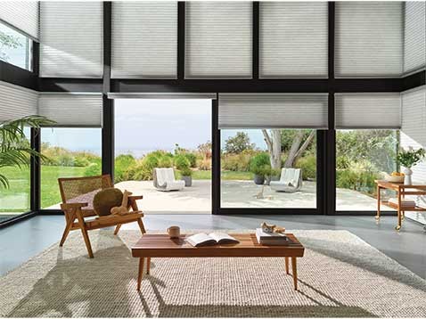 A room with a wall entirely made of windows, covered by shades