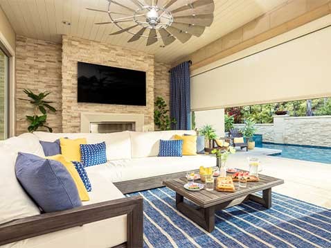 A bright, colorful room next to an open window showing a pool
